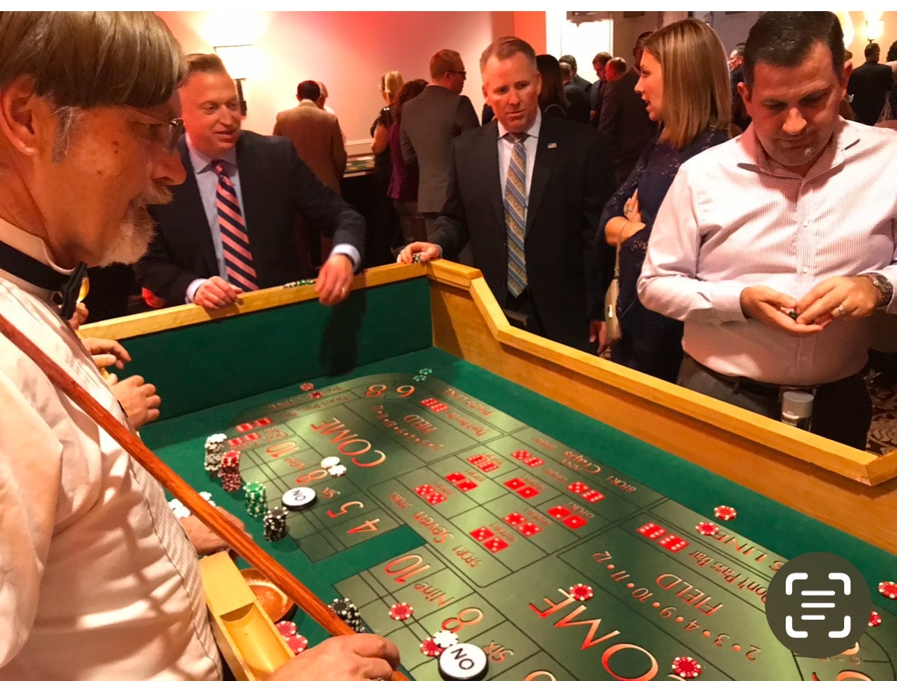 Guests gathered around a craps table at a casino party event